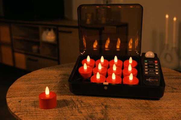 Een oplaadkoffer met 12 LED-kaarsjes rood oplaadbaar (waterdicht, timerfunctie, 175 uur, met afstandsbediening) staat open op een houten tafel, één kaars gloeit buiten; de schemerige kamer is versierd met meer kaarsen zonder vlam.