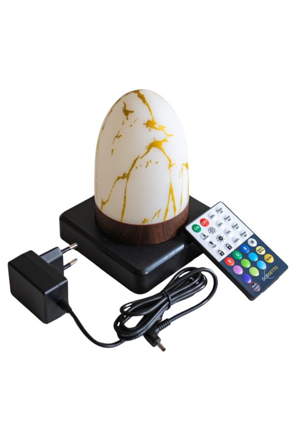 De oplaadbare tafellamp DORSETTO ovaal marmer goud (waterdicht, 105 uur) staat op een donkere basis, met bijgeleverde zwarte adapter en afstandsbediening met gekleurde knoppen.