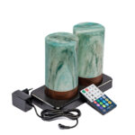 Two Tafellamp DORSETTO oplaadbaar 105 uur in cilindervorm, groen marmer houtlook, waterdicht en geleverd als set van 2 met afstandbediening op een zwart dienblad.