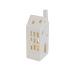 Een klein, wit Keramiek theelicht/waxine huis DORSETTO met een schuin dak en rechthoekige ramen, zachtjes verlicht van binnenuit, is afgebeeld tegen een effen witte achtergrond.