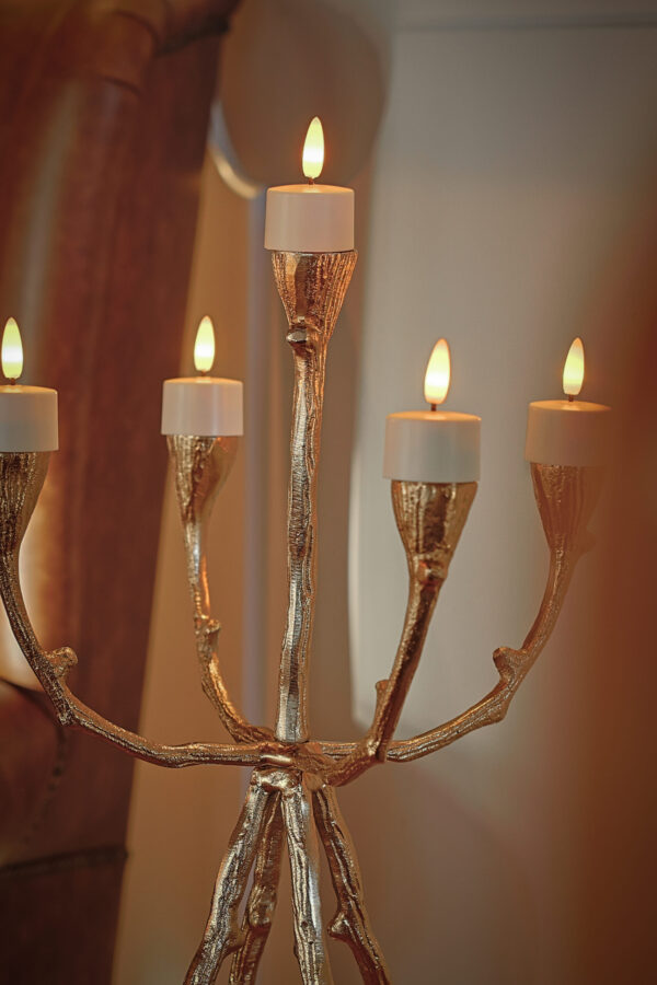 Een gouden kandelaar bevat zes LED waxinelichtjes 3D brandtijd 175 uur oplaadbaar, die elk binnenshuis warm opgloeien; deze oplaadbare kaarsen hebben een timer en afstandsbediening voor eenvoudig gebruik.