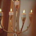 Een goudkleurige kandelaar met vijf brandende witte kaarsen is perfect voor LED waxinelichtjes 3D (brandtijd 175 uur, oplaadbaar, afstandsbediening, timerfunctie, 6 stuks) om een uitnodigende en elegante sfeer binnenshuis te creëren.