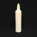 De Oplaadbare LED dinerkaars DORSETTO 97mm LOS, met een gele vlam, staat rechtop tegen een effen zwarte achtergrond.