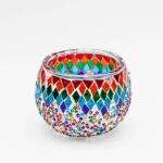 Theelichthouder gekleurde spikkels 9 CM DORSETTO is een ronde glazen kandelaar met kleurrijke spikkels en kleine kraaltjes in rood, blauw, groen, geel en wit op een witte achtergrond.