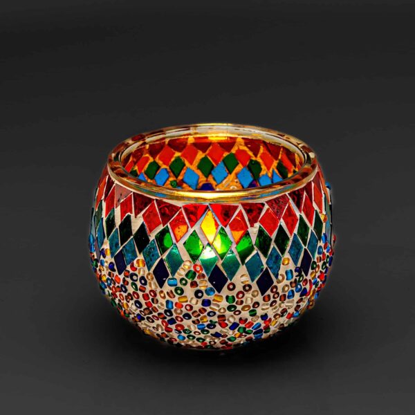 Theelichthouder gekleurde spikkels 9 CM DORSETTO: een ronde glazen kandelaar met levendige rode, blauwe, groene en gouden mozaïekdiamanten op een opvallende zwarte achtergrond.