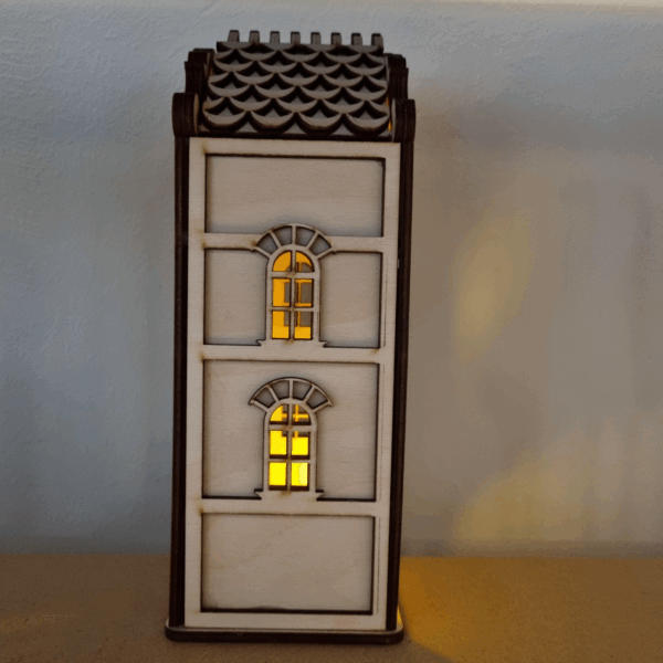 De Waxinelichthouder houten huis DORSETTO, met twee boogramen en een geschulpt dak, werpt een gezellige gele gloed die charme en warmte toevoegt aan elke ruimte wanneer hij tegen een effen muur wordt geplaatst.