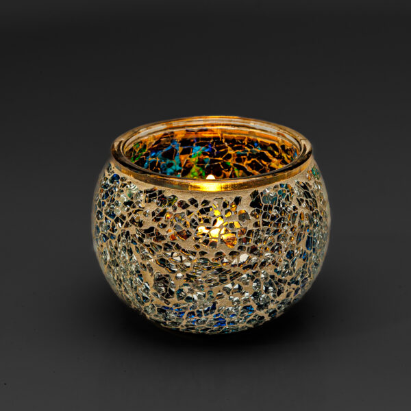 De Waxinelichthouder 9 CM Dorsetto mozaïek multicolor kandelaar, met gouden, blauwe en zilveren mozaïekfragmenten, gloeit warm wanneer hij van binnenuit wordt aangestoken en creëert een gezellige sfeer tegen een donkere achtergrond.