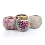 Vier Waxinelichthouder 9 CM Dorsetto mozaïek multicolor kandelaars in goud, paars, groen en neutrale tinten laten levendige mozaïekpatronen zien, bij elkaar gerangschikt op een wit oppervlak.