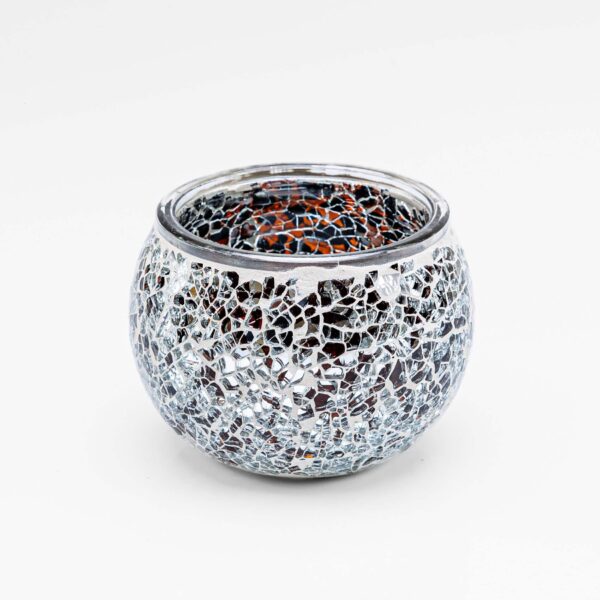 De Theelichthouder zwart 9 CM DORSETTO is een ronde glazen theelichthouder met een mozaïek van kleine, reflecterende zilveren en heldere glazen stukjes, afgebeeld tegen een effen witte achtergrond.