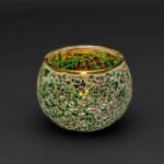 Theelichthouder DORSETTO 9 cm donker groen: een ronde glazen kandelaar versierd met groene en gouden mozaïektegeltjes, afgebeeld tegen een effen zwarte achtergrond.