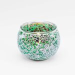 Theelichthouder DORSETTO 9 cm donker groen: een ronde glazen schaal met een mozaïekpatroon van kleine groene en zilveren reflecterende stukjes, afgebeeld tegen een effen witte achtergrond.