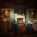 Een gezellige lounge met een brandende open haard, twee grote portretten, comfortabele banken, blauwe voetenbanken, warme verlichting en Dinerkaars 197mm LED DORSETTO oplaadbaar 130 uur warm met 12 stuks met afstandsbediening kaarsen op de schouw en tafels creëert een uitnodigende sfeer.