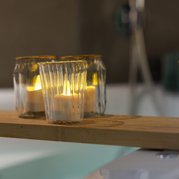 Twaalf oplaadbare LED-was/theelichtjes (brandtijd 175 uur, warm wit, waterdicht) met afstandsbediening creëren een warme en ontspannen sfeer, perfect voor gebruik in huis zoals op de badkamerplank.