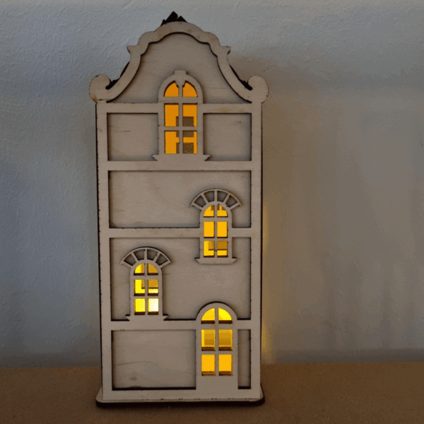 De Waxinelichthouder houten huis DORSETTO is een kleine, decoratieve kandelaar met boogramen en warmgele lichtjes die erachter schijnen, perfect om tegen een lichtgekleurde muur te plaatsen.