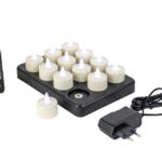 Ein Set aus 6 wiederaufladbaren LED-Teelichtern 3D mit bis zu 400 Stunden Brenndauer, Timerfunktion und Fernbedienung, dargestellt auf einer schwarzen Ladestation mit Netzadapter auf weißem Hintergrund.
