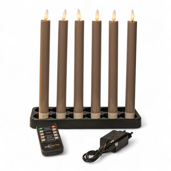 Sechs batteriebetriebene braune Kerzen mit flammenförmigen Spitzen sind in einem schwarzen rechteckigen Ständer angeordnet. Davor befinden sich eine Fernbedienung mit beschrifteten Tasten und ein schwarzer Stromadapter mit Kabel.