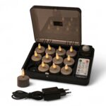 Ein Set mit zehn flammenlosen LED-Teelichtern in einem Ladeetui, mit einem Teelicht außerhalb des Etuis, einem schwarzen Netzadapter und einer Fernbedienung im Lieferumfang. Die Teelichter haben gelb-orange leuchtende Spitzen.