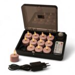 Eine schwarze Ladestation mit elf rosafarbenen LED-Teelichtern und einer Fernbedienung, wobei eine Kerze außerhalb der Station steht. Vor der Station befindet sich ein Netzadapter mit einem zweipoligen Stecker.