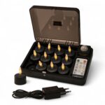 Ein Set aus zwölf schwarzen, wiederaufladbaren LED-Teelichtern in einem Ladeetui, mit einer Fernbedienung, einem Netzadapter und einem Teelicht, das außerhalb des Etuis steht. Alle Teelichter haben kleine gelbe Flammen.