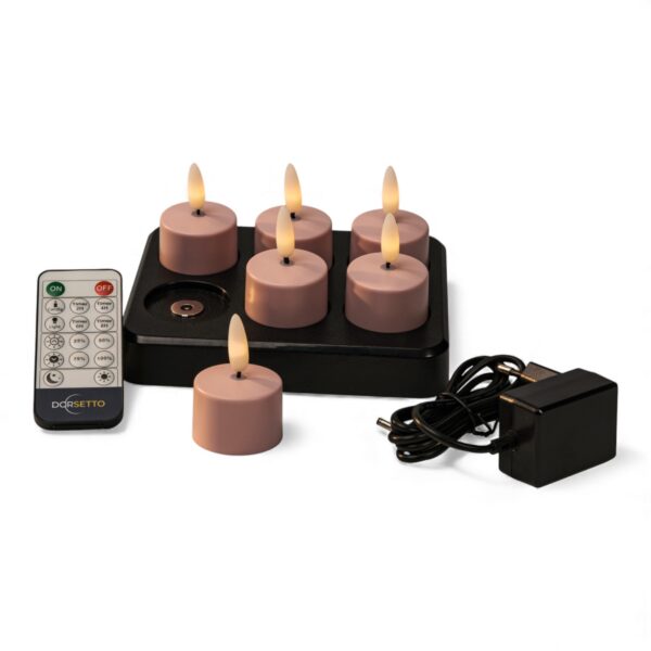 Ein Set aus sechs rosafarbenen LED-Teelichtern mit einer schwarzen Ladestation, einer Fernbedienung und einem Netzadapter, alles auf weißem Hintergrund.