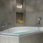 Eine moderne Badewanne mit Mosaikfliesen verfügt über eingebaute Regale, die LED-Teelichter wiederaufladbar mit Fernbedienung, wasserdicht und bis zu 400 Stunden Brenndauer, sowie Keramikhäuser aufnehmen und eine gemütliche und entspannende Atmosphäre schaffen.